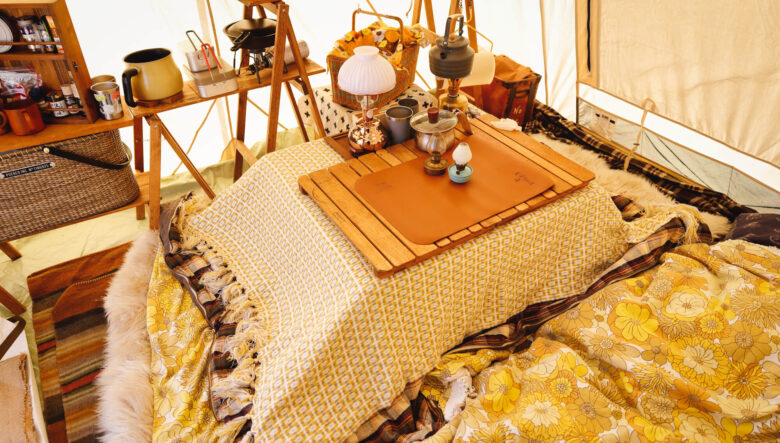 室内のリビングはコタツスタイル。折り畳みのテーブルにブランケットを掛け、アウトドア用のウッドテーブルを載せている。中には湯たんぽを入れ保温しているそう。