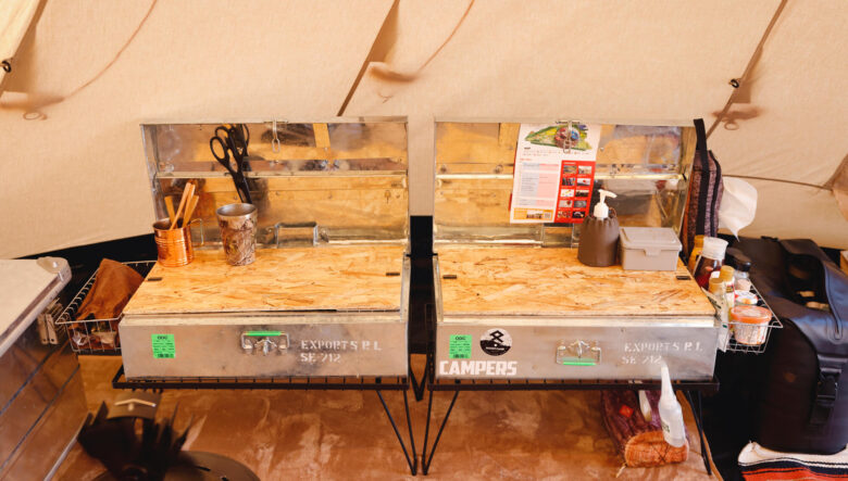 キッチン台として使っているスチールコンテナは、ノーブランドのラックにセット。内蓋のようにOSB素材で天板を自作したそうで、ここの上で調理可能に。左右にはメッシュのバスケットまで付き、使い勝手も考えられている。