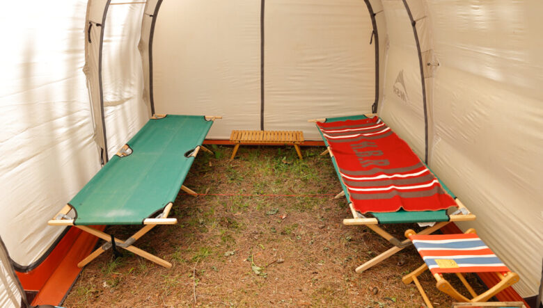 テント奥の寝室スペース。バイヤーオブメインのメインヘリテージウッドコットを2つ並べた。木製のコットならではの温もりがたまらない。ヴィンテージの毛布を合わせて、くつろげる空間となっている。