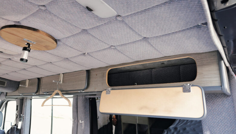 天井の収納に付けたハンガーラックは持ち手と兼用。