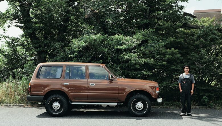 オールペンしたメタリックブラウンは、往年のセドリックやアメリカのキャンピングカーをイメージしたオ リジナルカラー。2インチリフトアップしたタフなルックスに、無骨なオールテレーンタイヤがマッチ。