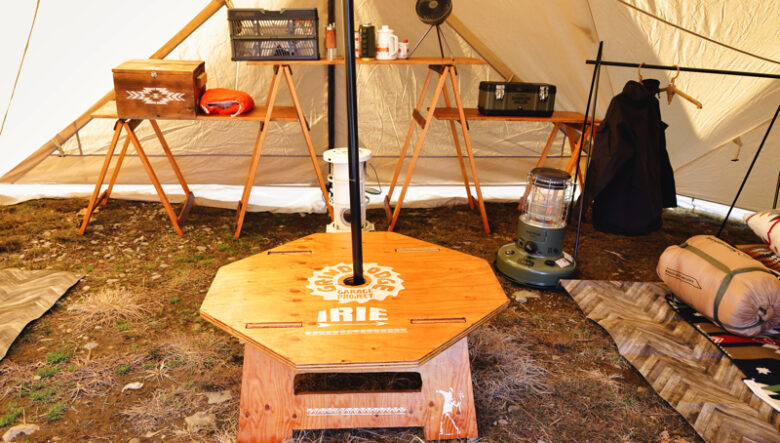 テントの中央に設営されたポールを挟むように、自作のウッドテーブルをセッティング。ここから左右に分かれてそれぞれのプライベートスペースを作っていた。