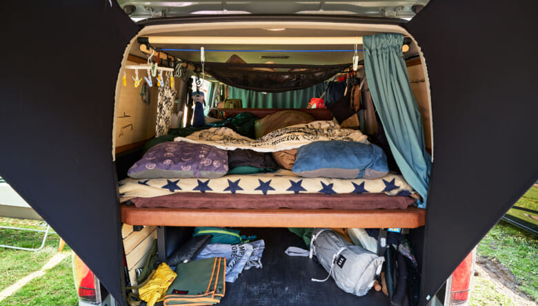 トヨタのハイエースは昨年購入したばかり。ベッドキットを入れ、天井には自作のポールで使い勝手を向上させた。