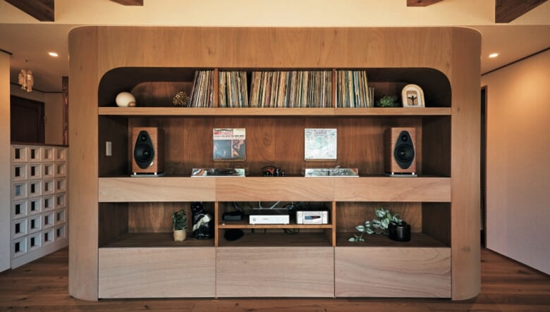 家屋の中央に鎮座する、レコード棚を兼ねたDJブース。薄いグレーのオイルで仕上げたラワン合板で構築され、両サイドをラウンドさせた美しいデザインが特徴的。スピーカーは、ソナス・ファベールのソネットⅡ G2。