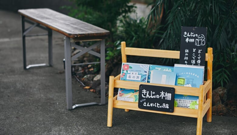 桜の木の下にはベンチを設営。その脇にあるのは『きんじょの本棚』。街に開かれた青空文庫で、設置場所は全国で200箇所以上。「誰でも読めるし、どこに返却してもらってもいいフリーの活動です」。