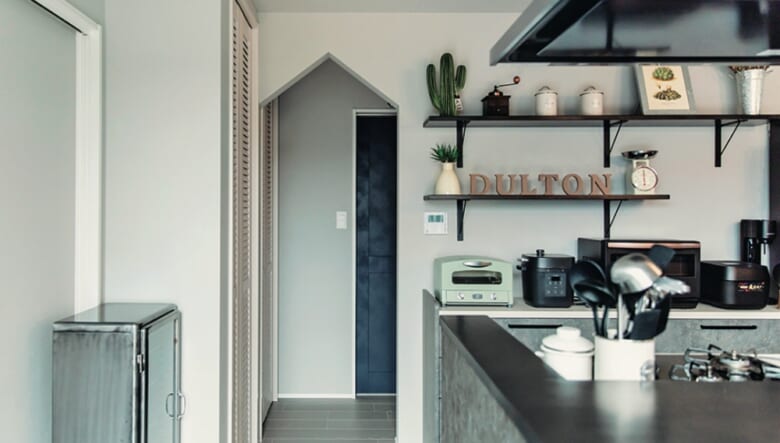 キッチン奥にまとめて配置した水まわり。その空間をつなぐ入り口も三角の垂れ壁に。