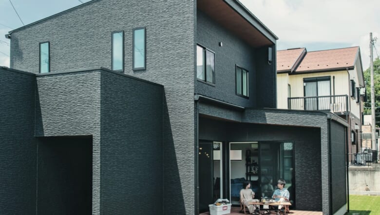 外壁は金属・サイディングが選べるなかで黒系のサイディングをチョイス。アウトドア好きなら欠かせないウッドデッキは、リビングからひと続きすることで、家の中と外をシームレスにつなげるような設計となっている。