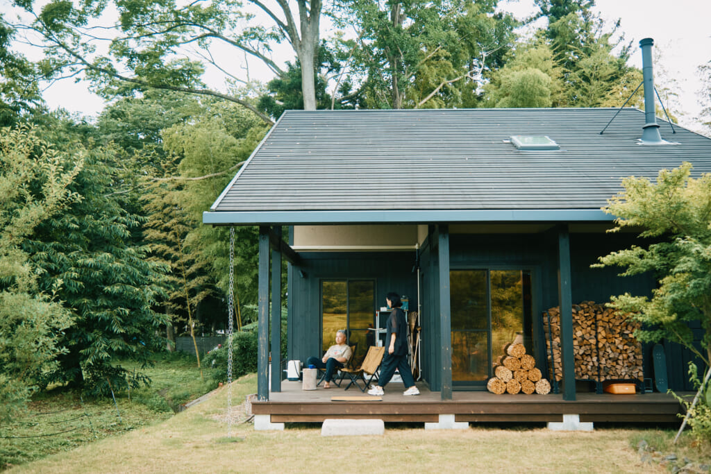 玄関から続くウッドデッキは、リビングの窓からもアクセスできる広縁につながる。冬場の薪ストーブ用に、使い勝手のいい玄関脇に薪をストック。