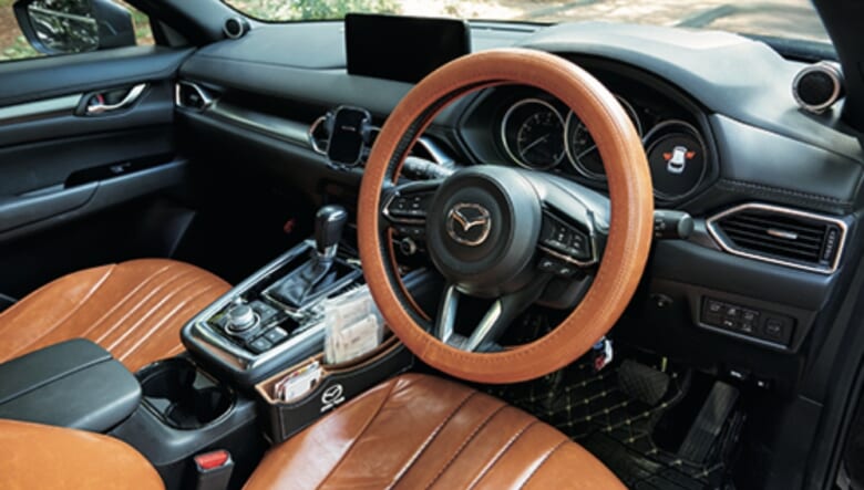 ステアリングカバーとシートカバーはフェイクレザー。「車種に合わせて作ってくれるところにセミオーダーしました」。