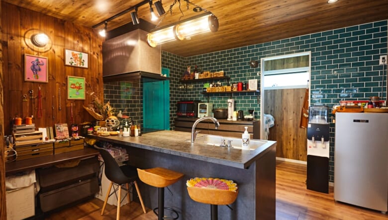 対面式カウンターが好みに合ったというキッチン。カウンターは香名さんが扱いやすい高さにし、奥の壁のタイルや扉の色にもこだわった。奥にはパントリーを備える。