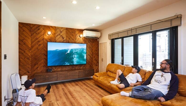 石岡さんと、長男・怜大くん、次男・建人くん。シンプルなリビングだが、大迫力の映像を楽しめるデッカいテレビには唯一こだわったとか。