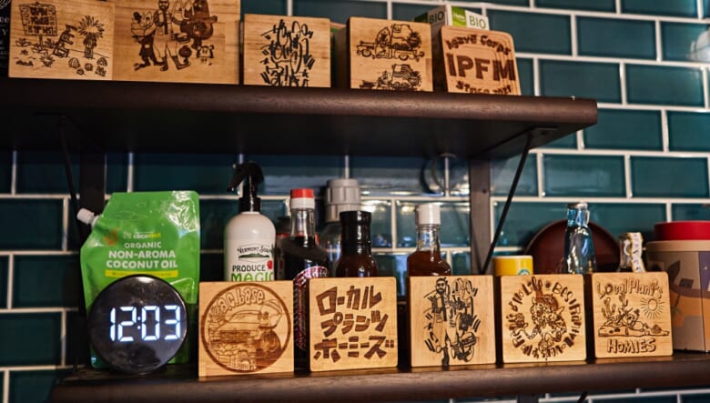 アメ車や植物仲間にはアーティストや作家も多く、キッチン奥の棚に飾られた木板も、そんな仲間のひとりkazz lazerによる作品。

