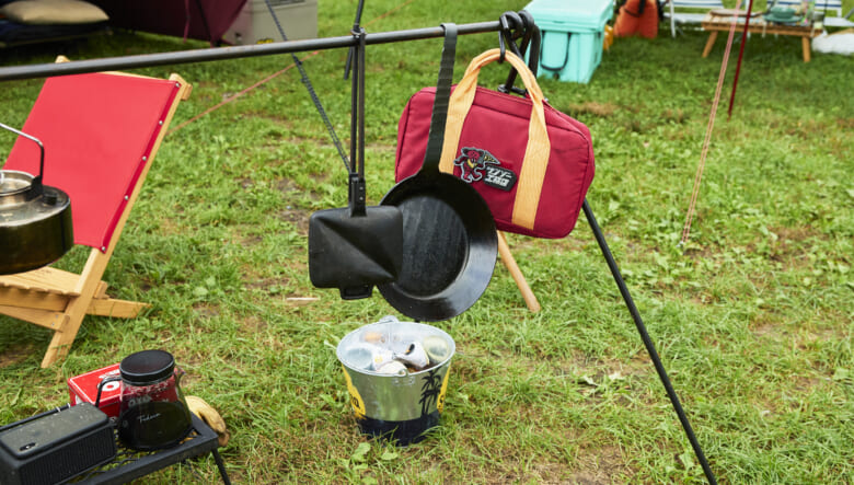 サンゾー工務店のアイアンハンガーには、焚き火調理用のアイテムが。オイゲンのホットサンドクッカーやタークのフライパンを吊り下げている。