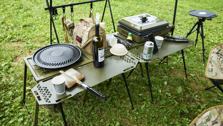 ブッシュ ド ブラントのテーブルは、色やステッカーでカスタム。左はスノーピークのフラットバーナーが入る設計となり、これひとつでキッチンまで兼ねる。