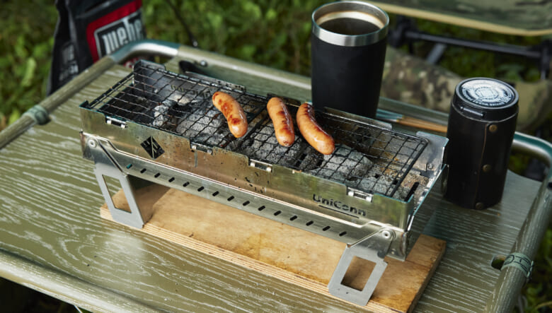 テーブル上はユニファイヤーピッツで調理中。コンパクトなサイズで、卓上BBQが楽しめるためソロキャンにもオススメ。