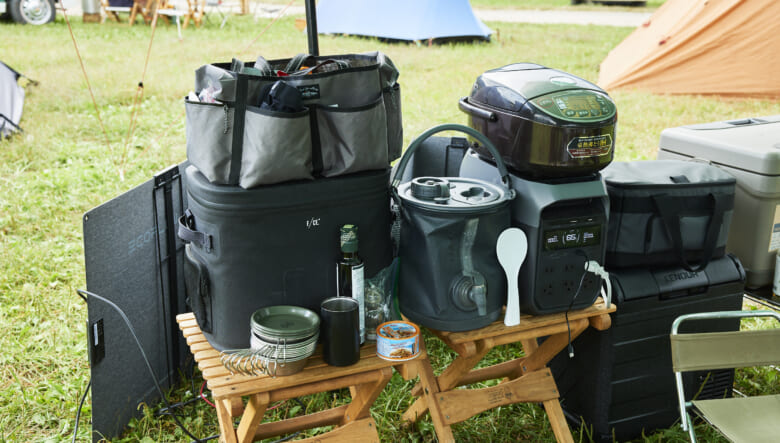 エコフローのバッテリーがあれば、キャンプ場ながら炊飯器でお米を炊くこともできる。バイヤーオブメインのサイドテーブルに収納ボックスやジャグなどもひとまとめ。