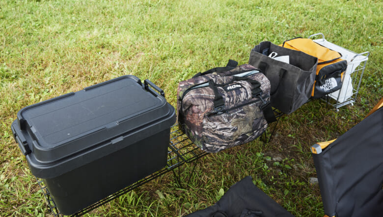 イスから手の届く範囲に収納ボックスやクーラーボックス類を配置。ユニフレームのフィールドラックも黒で揃え、コンパクトにレイアウト。