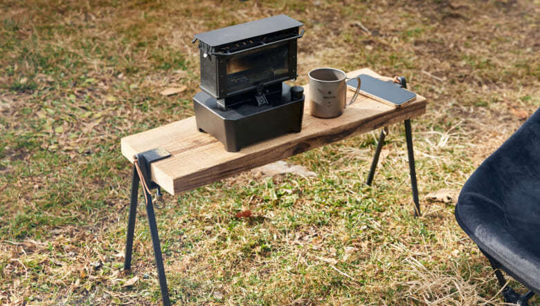 テーブルは、ラマで購入した脚に足場板を挟んだもの。上に乗せたH7プロジェクトのアイロンストーブは、小さな薪ストーブのように手軽に炎が楽しめる。