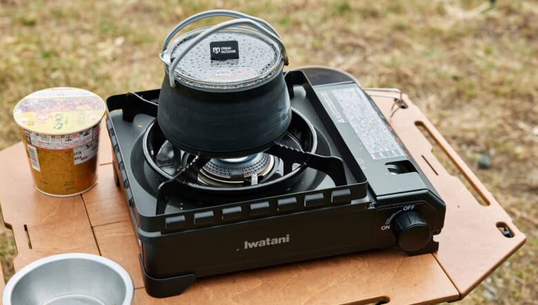 黒で統一したサイトに似合う、イワタニのたふマル。テーブルはヘリノックスのテーブルの脚にマクアケで見つけた天板を取り付けている。