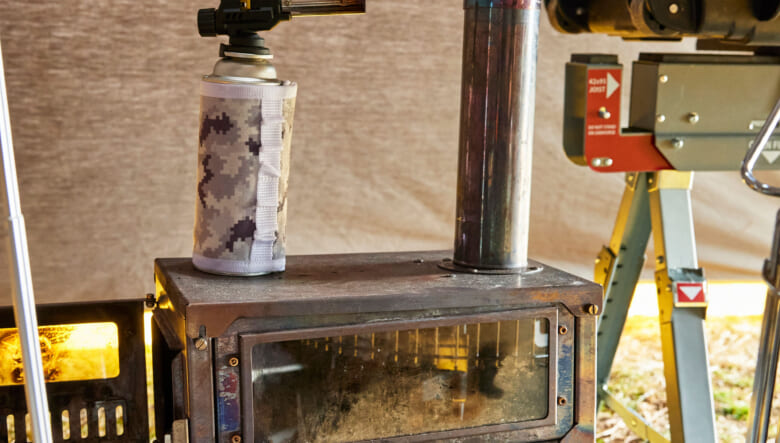 フィールドラックのメッシュラックの上には、スームルームのコンパクトな薪ストーブをセッティング。室内にいながら焚き火気分を味わうことができる。