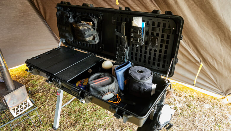 こちらが自作のキッチン台。ナチュラルマウンテンモンキーが展開するデックスボックスを参考に、ロングタイプのハードケースを、ホームセンターで見つけたソーホースの上にセットしてDIY。フタ内側には、モールでパーツが取り付け可能なクルマ用のパネルを仕込んで小物収納に。