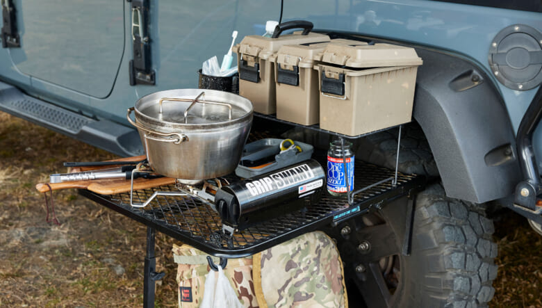 オーバーランドスタイルのキャンプに欠かせないタイヤテーブルをキッチン台として活用。メッシュ素材なのでダッジオーブンなど熱いものも直置きできる。