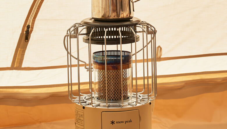 テント内を暖めているのは、スノーピークのグローブストーブ。天板には同ブランドのケトルを置いて加湿。