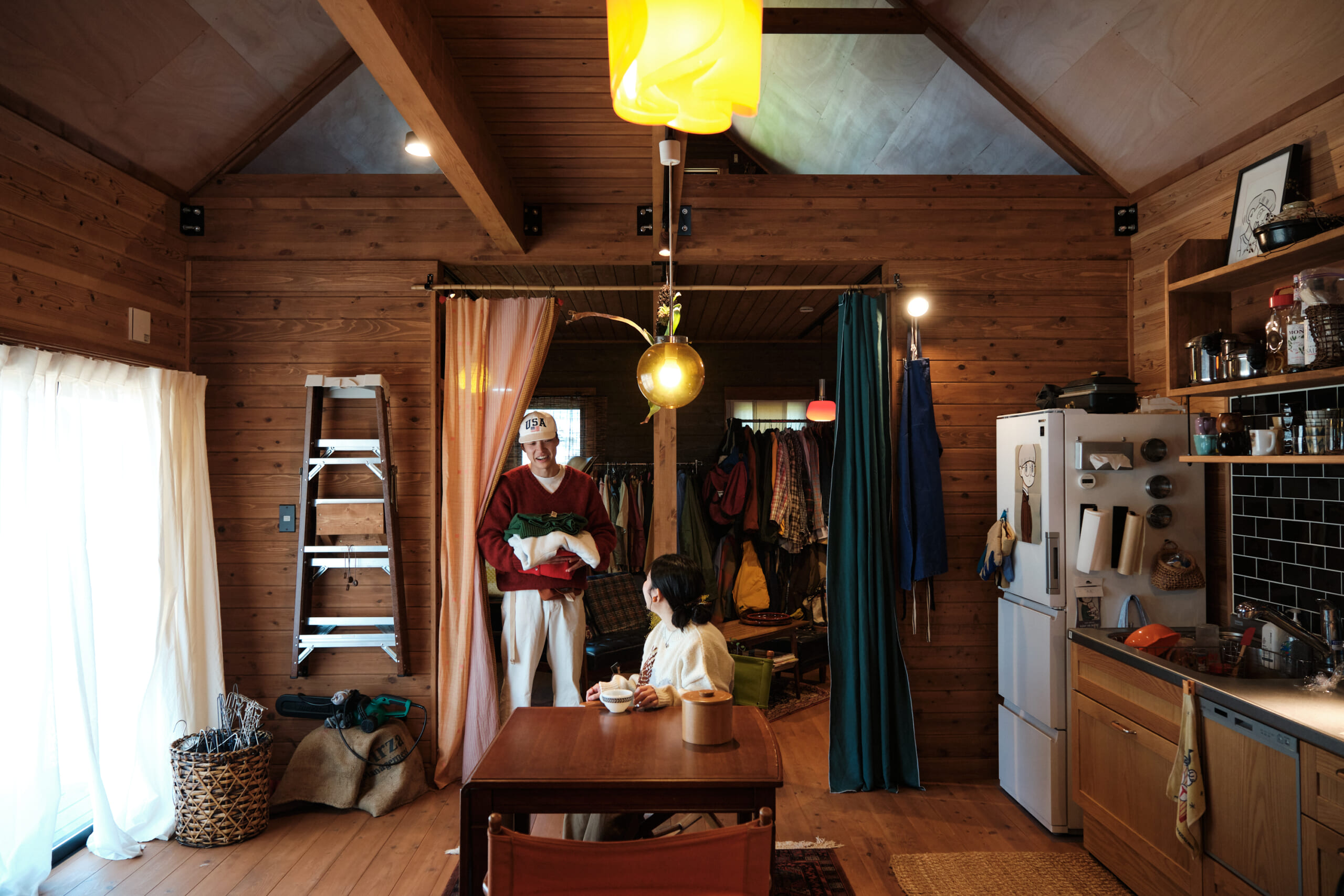 服を選んでいるごっしーさんがダイニングにいるまゆかさんに話しかけている様子