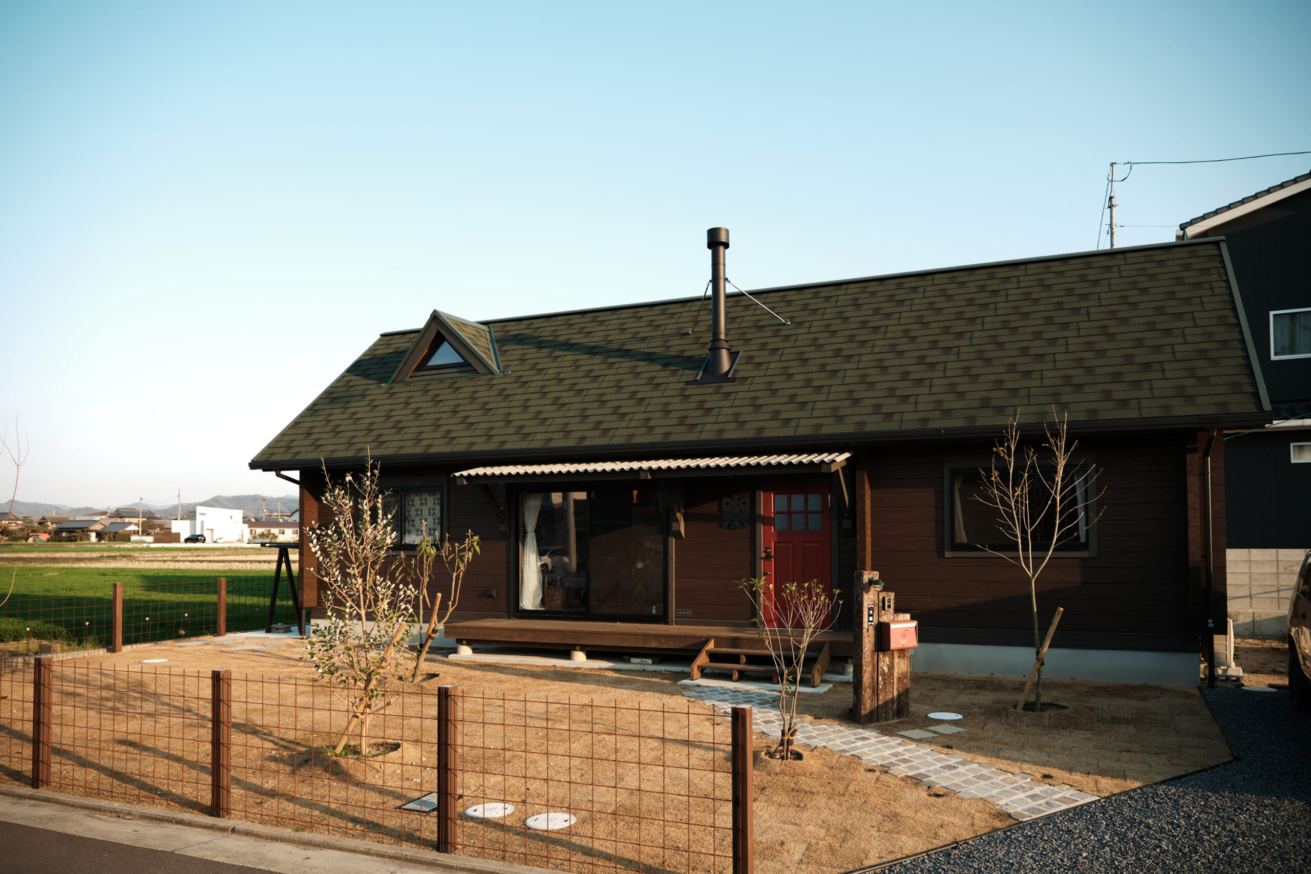 緑の屋根に煙突がついた栖ログの外観