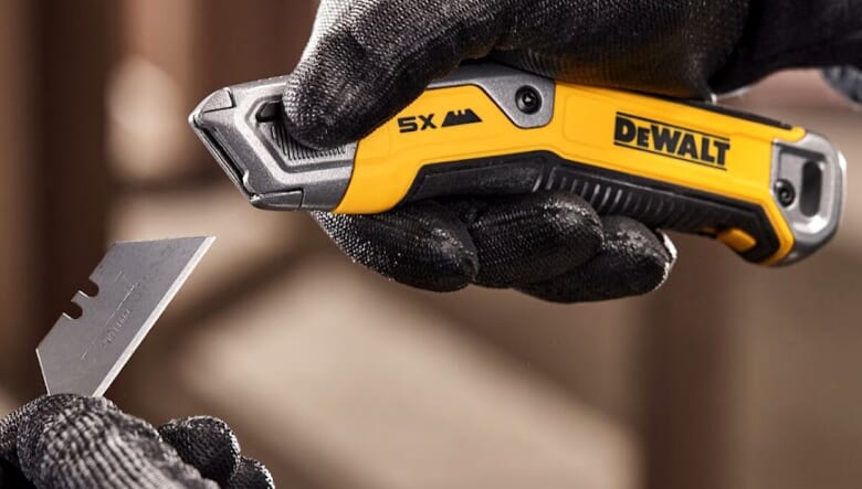 Worker changing utility blade on DEWALT® DWHT10998 Utility Knife