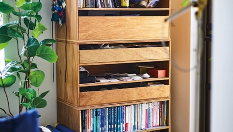 ディアンドデパートメントで買った中古の箱を積み上げて棚のように使う。デザインが異なる仕切りや引き出しに、CD、文庫本、雑誌、小物をムダなく収納。