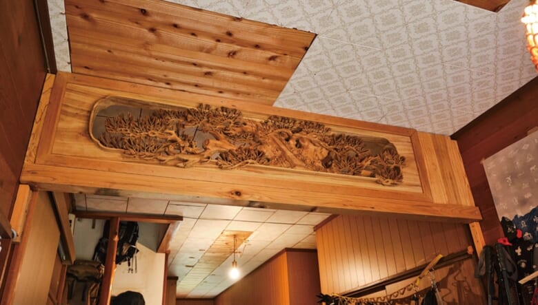 玄関の欄間は、地元の小道具屋で見つけた逸品を後付けしたもの。あえて玄関に飾って、この家のアイコン的な存在に。「立体的な模様にひと目惚れしました」。